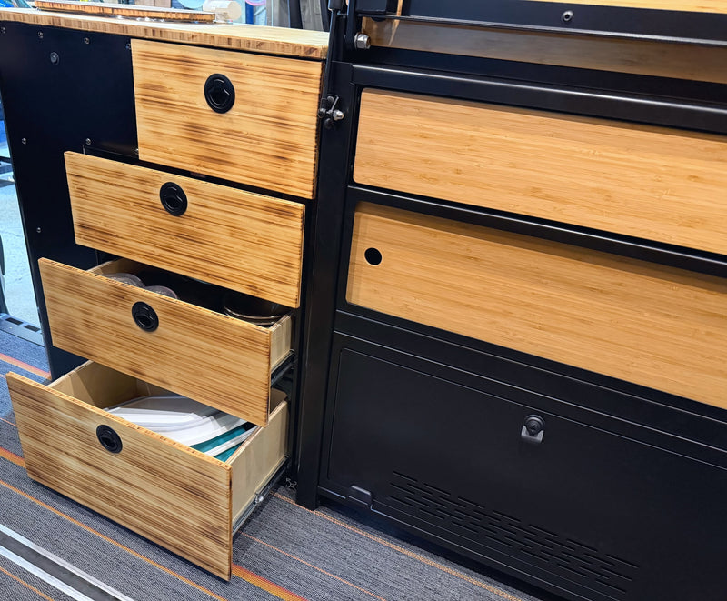 RV rental interior features compact, organized storage with charred bamboo drawers & black latches in a sleek black module. — photo 5