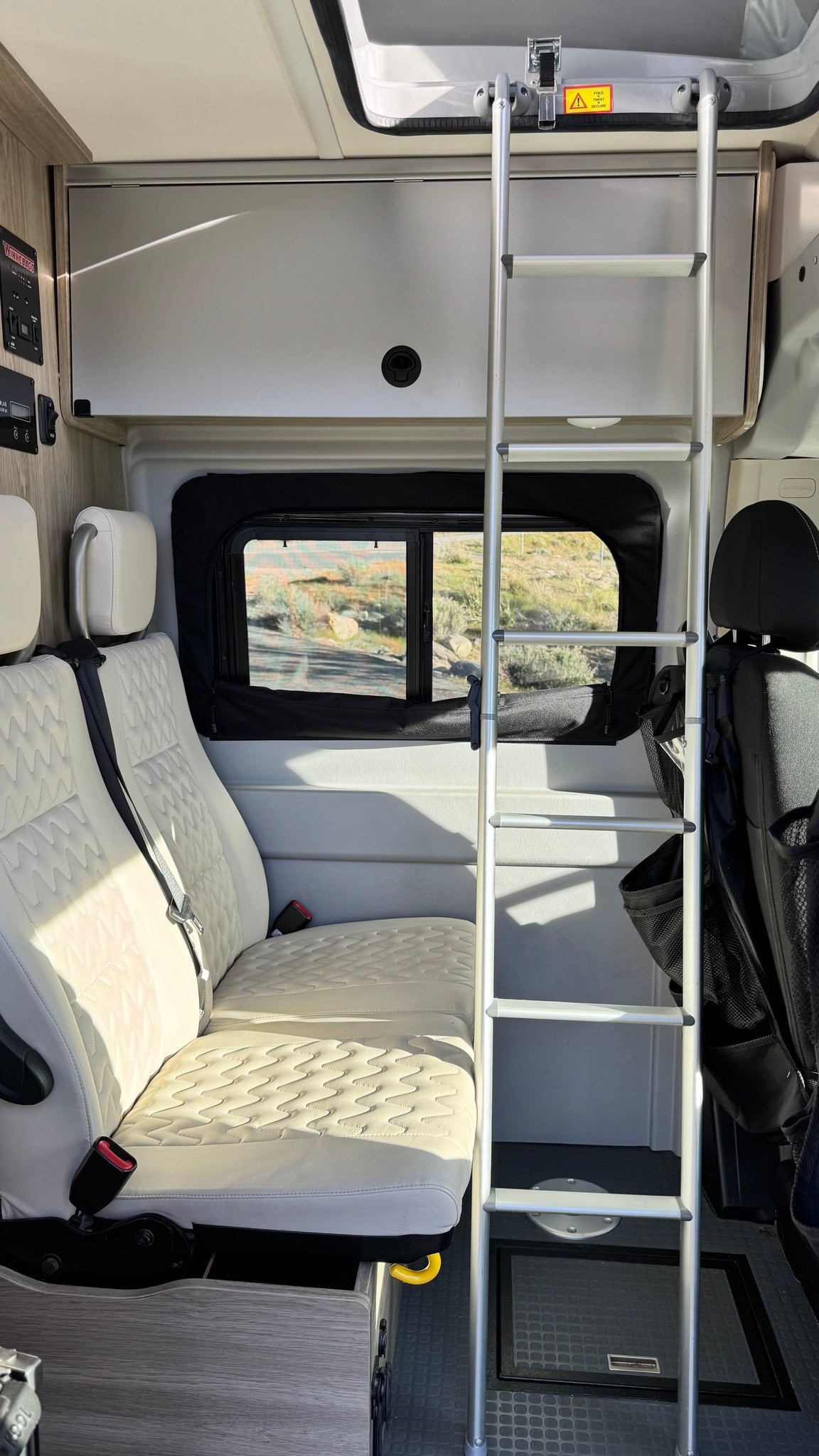  protected by an insect screen.|RV rental rear view: open van doors show a functional sleeping setup with a bug screen — photo 11