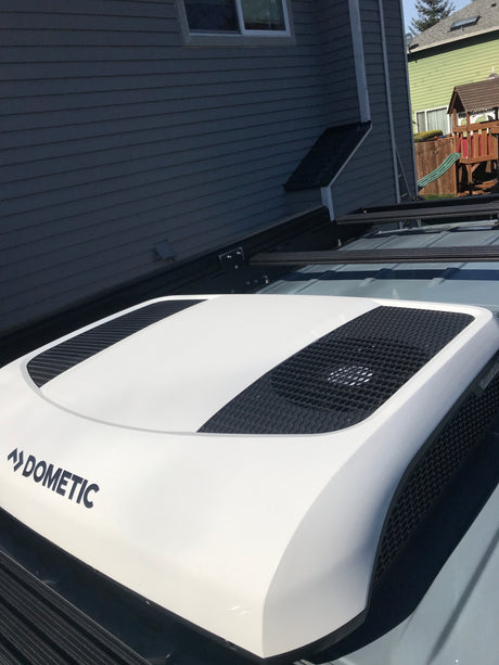 Close-up of a white Dometic rooftop AC unit on an RV rental, providing cool comfort for your travels.