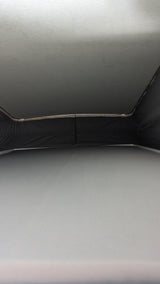 RV rental pop-top view: Raised ceiling, dark fabric walls, and mattress inside a campervan for comfortable travel.