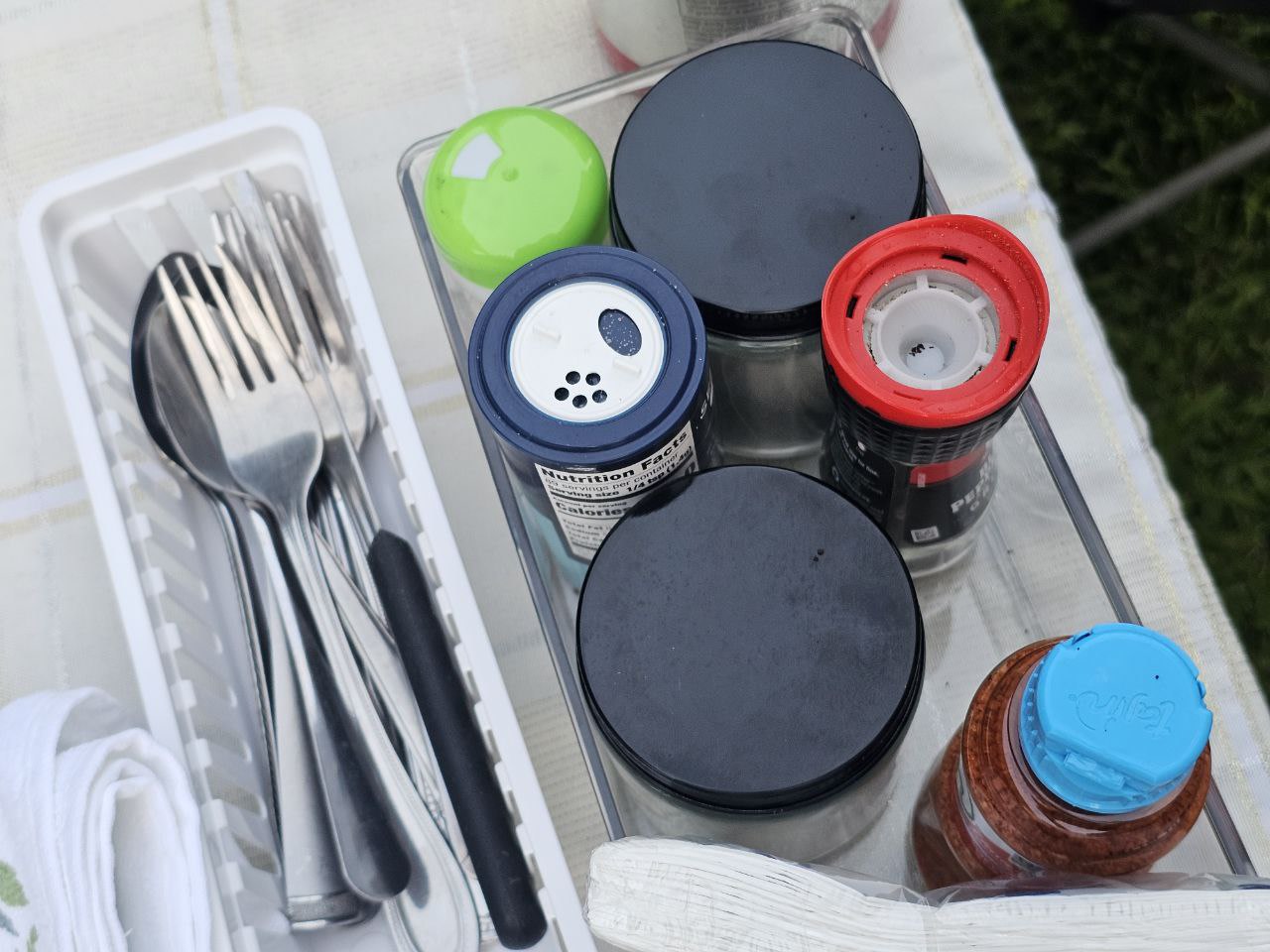 RV rental camp kitchen: Organized silverware, spices, and a pepper grinder ready for outdoor meals.