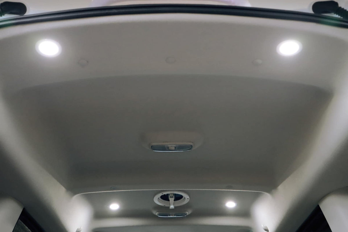  and fridge for camping.|RV rental interior: A pull-out tray & open drawer next to a bed show smart storage in a compact camper.|View inside an RV rental camper van — photo 4