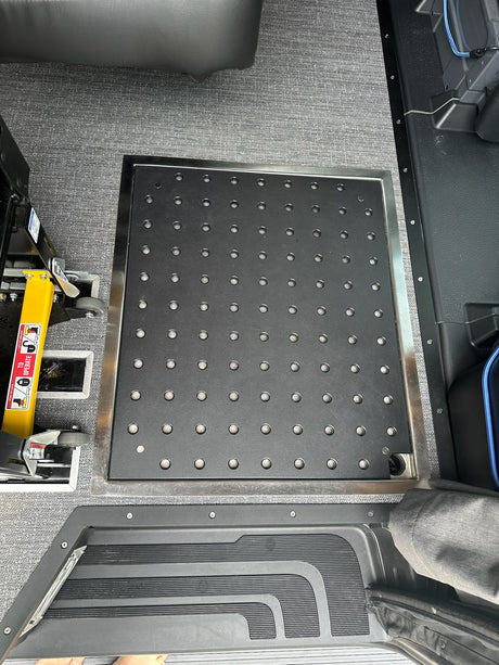 RV rental interior: Versatile floor tie-down system and wheelchair lift component for accessibility.