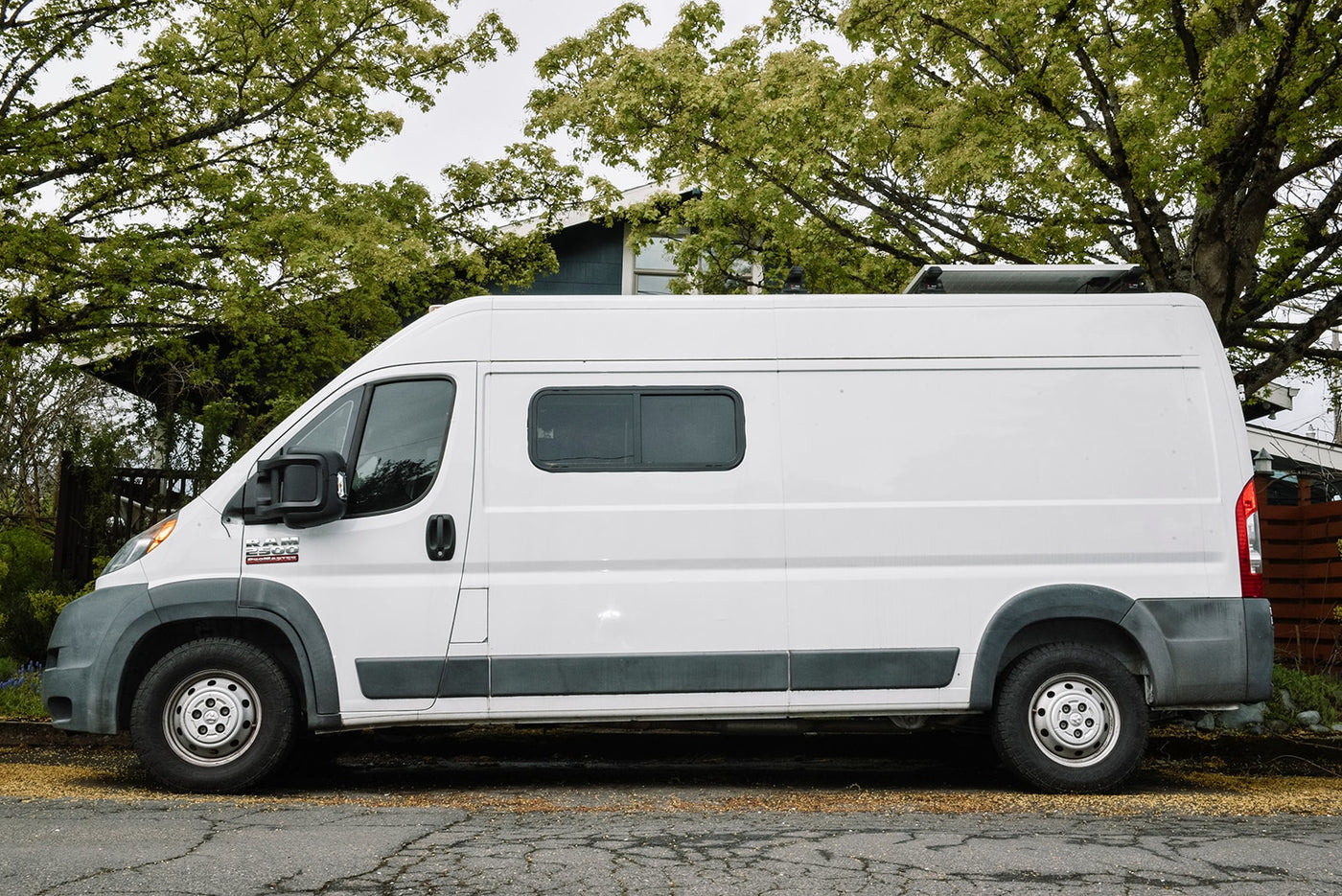  ready for adventure by a rustic shed. Consider this ideal RV rental for your next outdoor trip.|A white Ram ProMaster converted camper van — photo 3