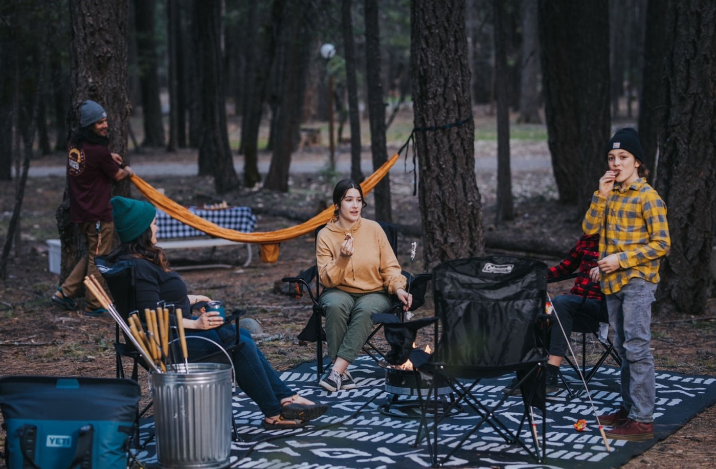  perfect for an RV rental adventure.|Outdoor cooking & relaxation with your RV rental. A couple prepares food and drinks under a canopy tent in the woods.|Forest campsite activity: People set up a large tent — photo 17