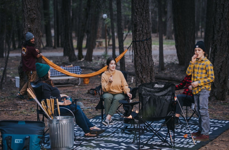  perfect for an RV rental adventure.|Outdoor cooking & relaxation with your RV rental. A couple prepares food and drinks under a canopy tent in the woods.|Forest campsite activity: People set up a large tent — photo 17