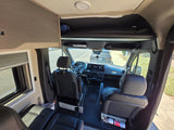RV rental: Mercedes-Benz campervan interior showing cockpit, front seats, and overhead bunk.