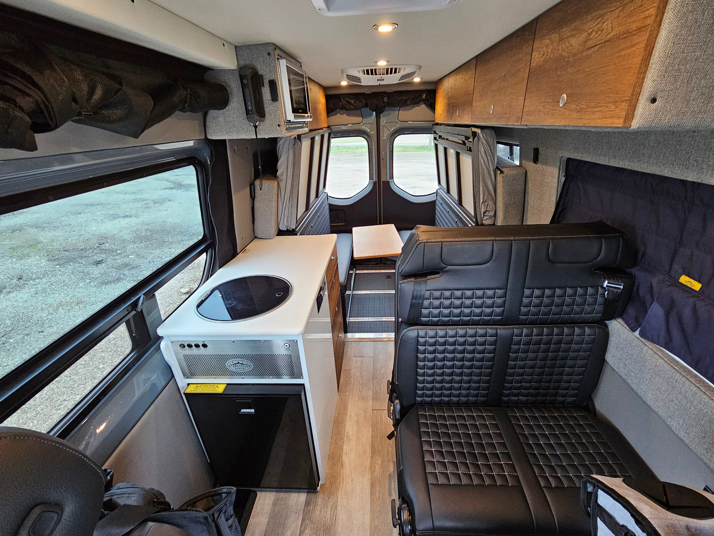 Explore this modern rv rental interior featuring a compact kitchen, plush seating, and storage, perfect for adventures.