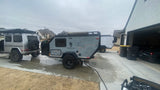 A G-Wagon tows a sleek Mission Overland RV trailer, ready for adventure. Explore RV rental options for similar trips!