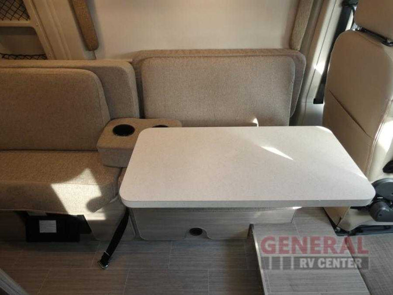 RV rental interior: cozy dinette with light-colored bench seats, a central table, and cup holders. — photo 8