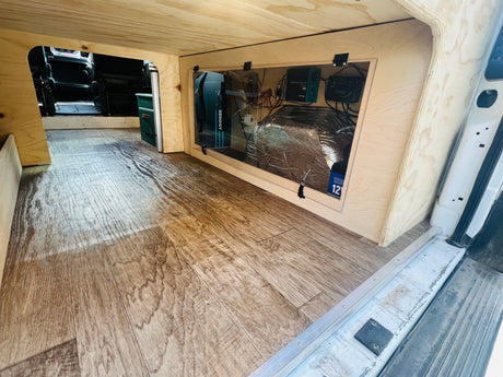 RV rental campervan interior features wood flooring, custom cabinetry, and a visible electrical system with Renogy power components.