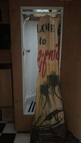 RV rental: Compact shower & toilet area with a "Welcome to California" curtain and checkered floor.