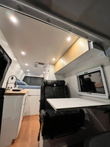 Spacious RV rental interior with kitchen, bed, and dining area, perfect for a comfortable road trip.
