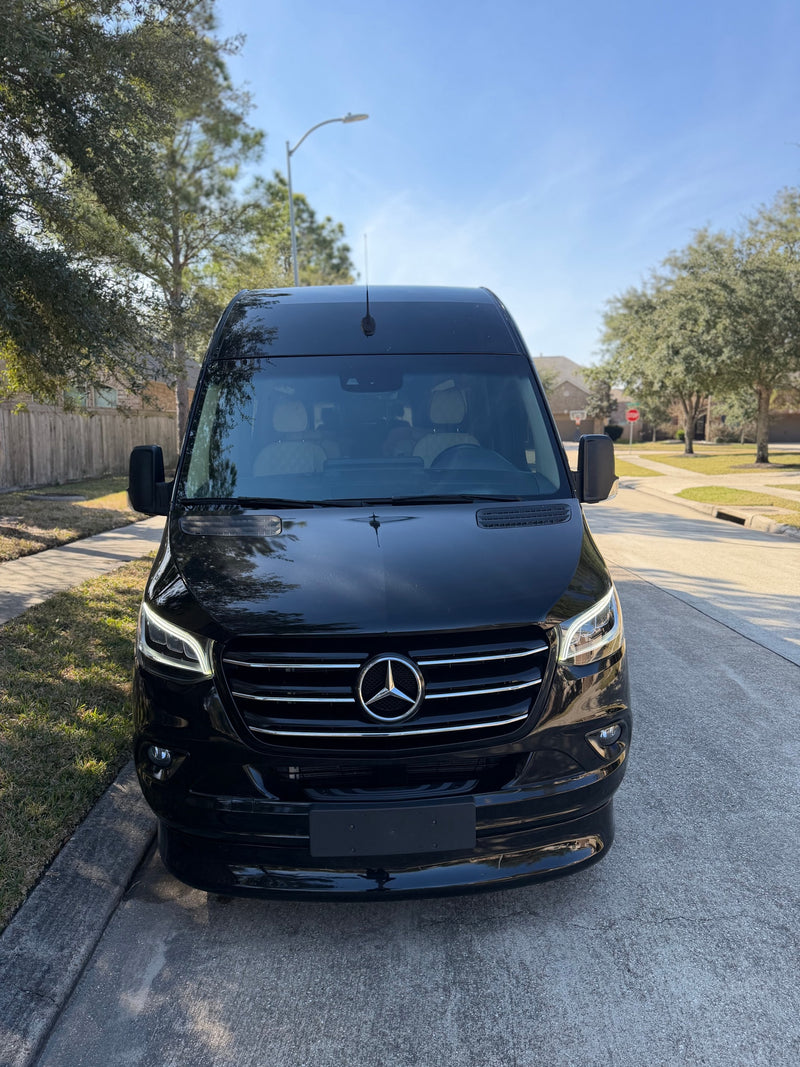 Black Mercedes Sprinter van, perfect for an rv rental, parked on a sunny residential street with trees and houses. — photo 8