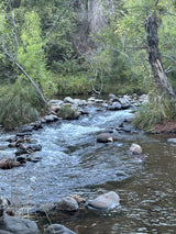 Serene river with rocky rapids & lush banks, ideal for nature lovers. Explore hidden gems after your RV rental adventure.