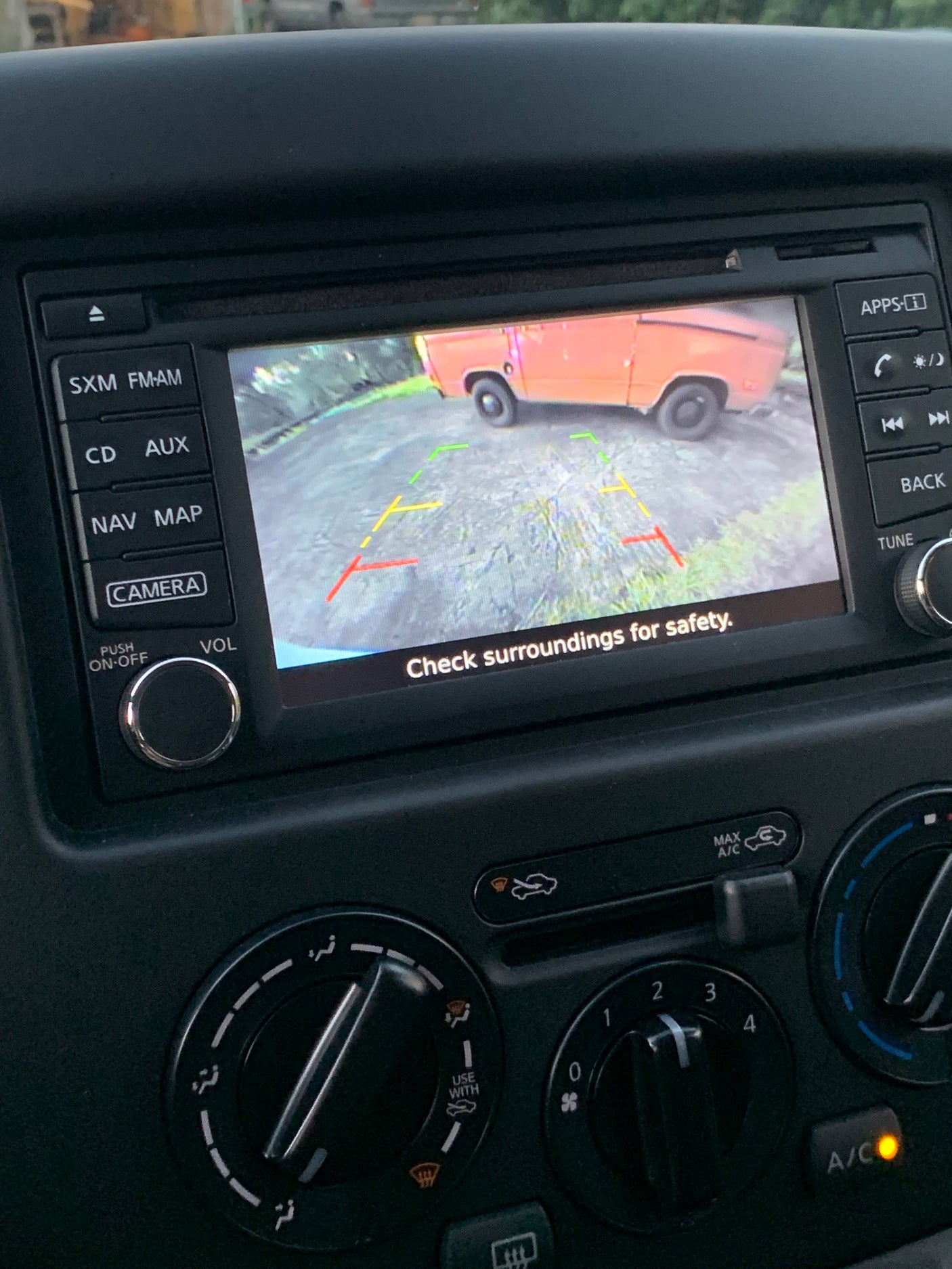 Dashboard screen shows an orange RV rental in rearview camera view, with parking lines and a safety message.