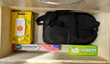 Organized RV rental drawer: disinfecting wipes, aluminum foil, sandwich bags & black bag for essentials.