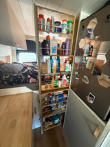 This RV rental features a clever pull-out pantry, maximizing storage for essentials next to the bed and compact kitchen area.