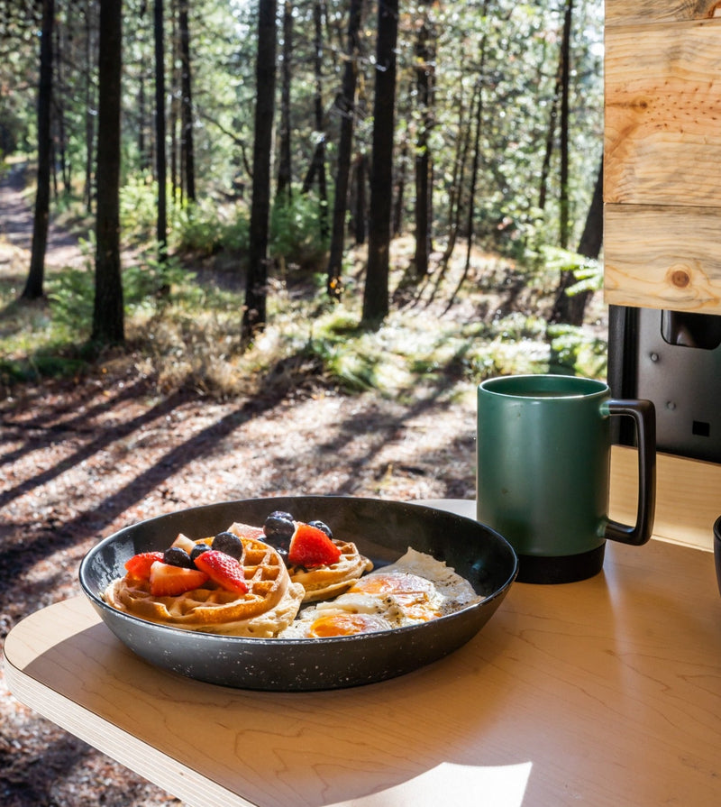  parked in a snowy forest.|This RV rental Ram ProMaster camper van is parked with its side door open — photo 8