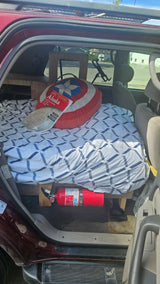 This DIY camper conversion for an RV rental features a bed, Captain America pillow, Alaska map, and fire extinguisher for safe travel.