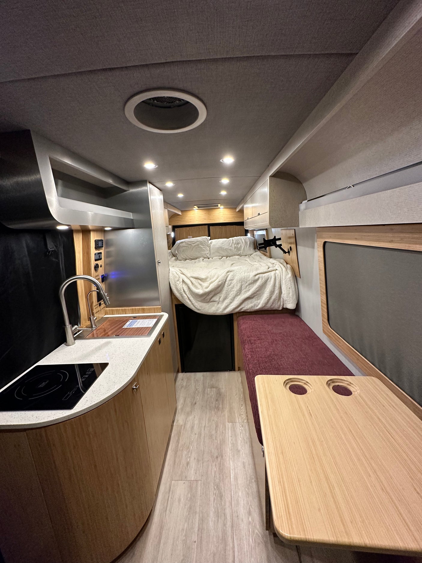 Spacious RV rental interior: modern kitchen, cozy bed, and dinette. Ideal for mobile living comfort.