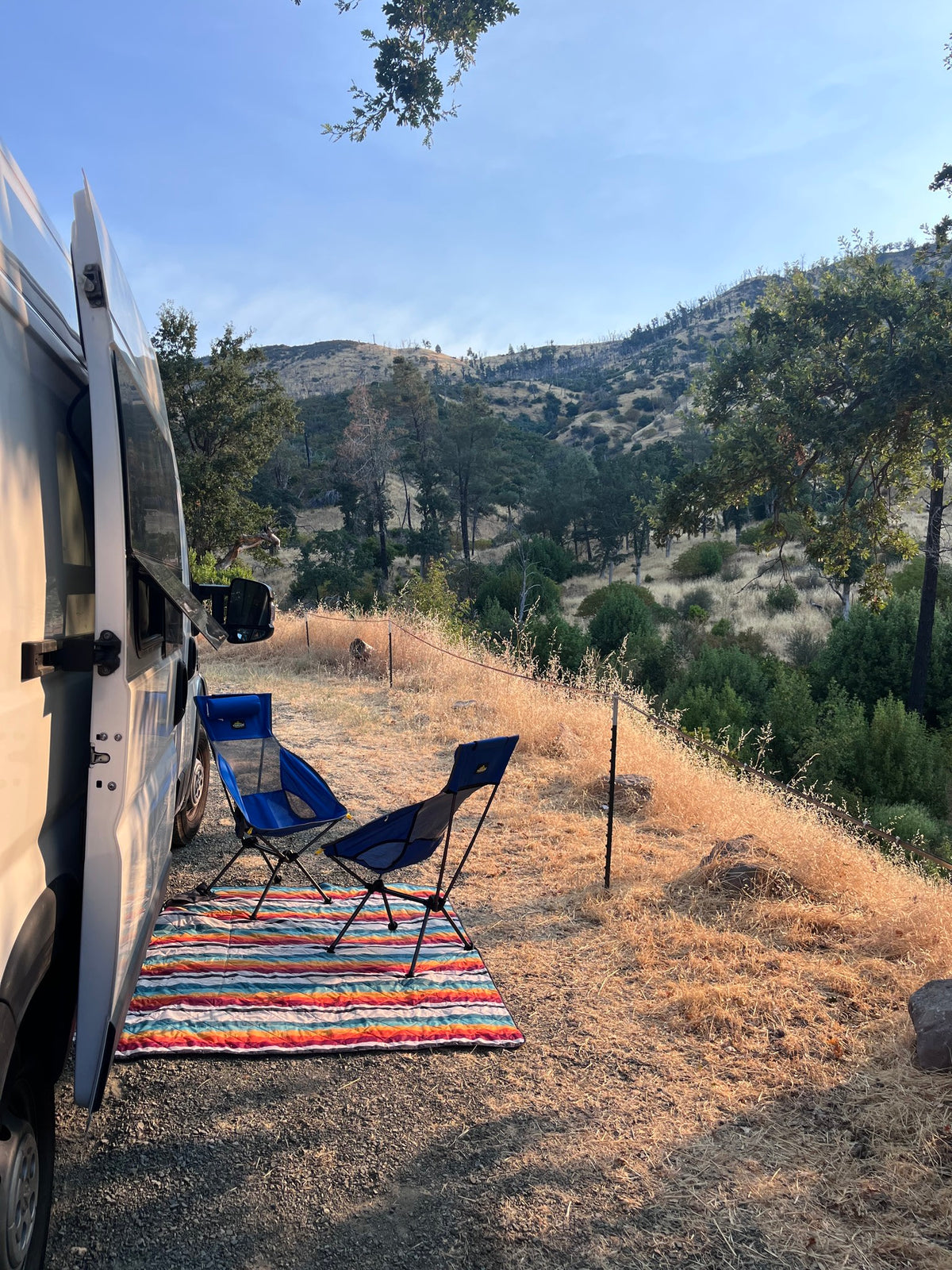  parked by the ocean with scenic views.|An rv rental set up for camping: white camper van