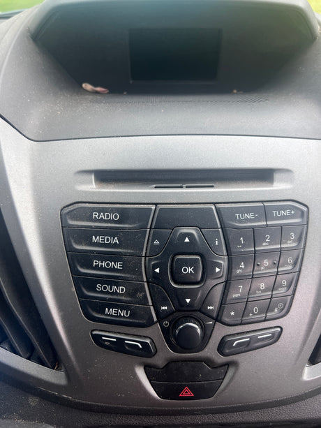 Dusty RV rental car dashboard, showing the radio/media control panel with a numeric keypad and an empty screen area.