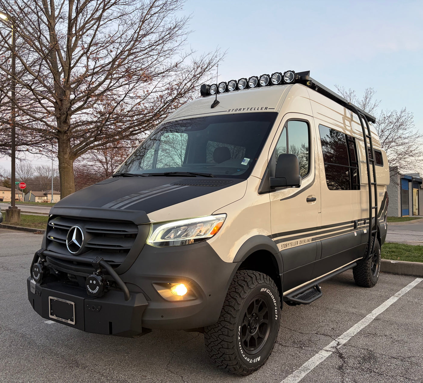 Storyteller Overland Mercedes Sprinter adventure rv rental van, with off-road tires, rooftop lights, and rugged bumper.