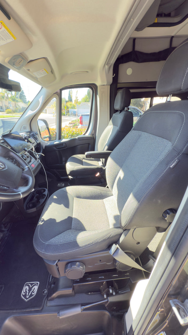 Inside this Ram rv rental van: a view of the front cabin, showing gray fabric seats, steering wheel, and dash. — photo 15