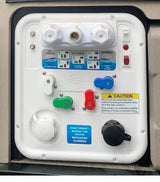 RV rental service bay: A white control panel with various water hookups, valves, and instructions for winterizing.