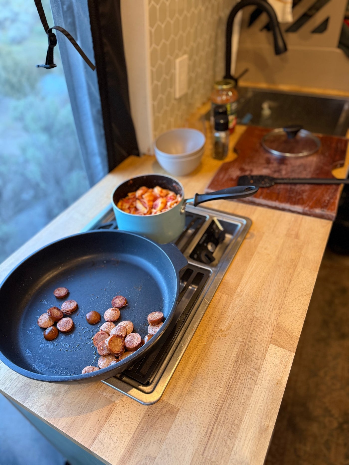  a pan sits on a stovetop with olive oil nearby. The large window reveals a vast — photo 7
