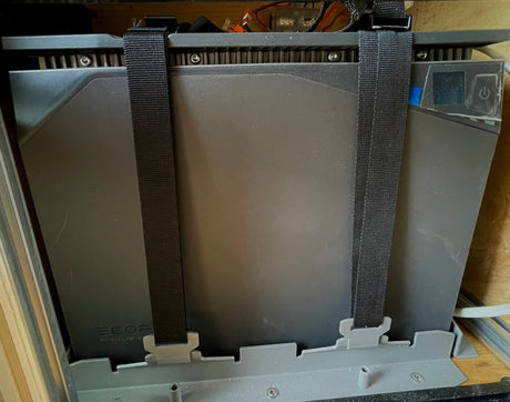 A dark gray EcoFlow 2KWH LFP battery secured with black straps. Ideal for off-grid RV rental adventures & portable power needs.