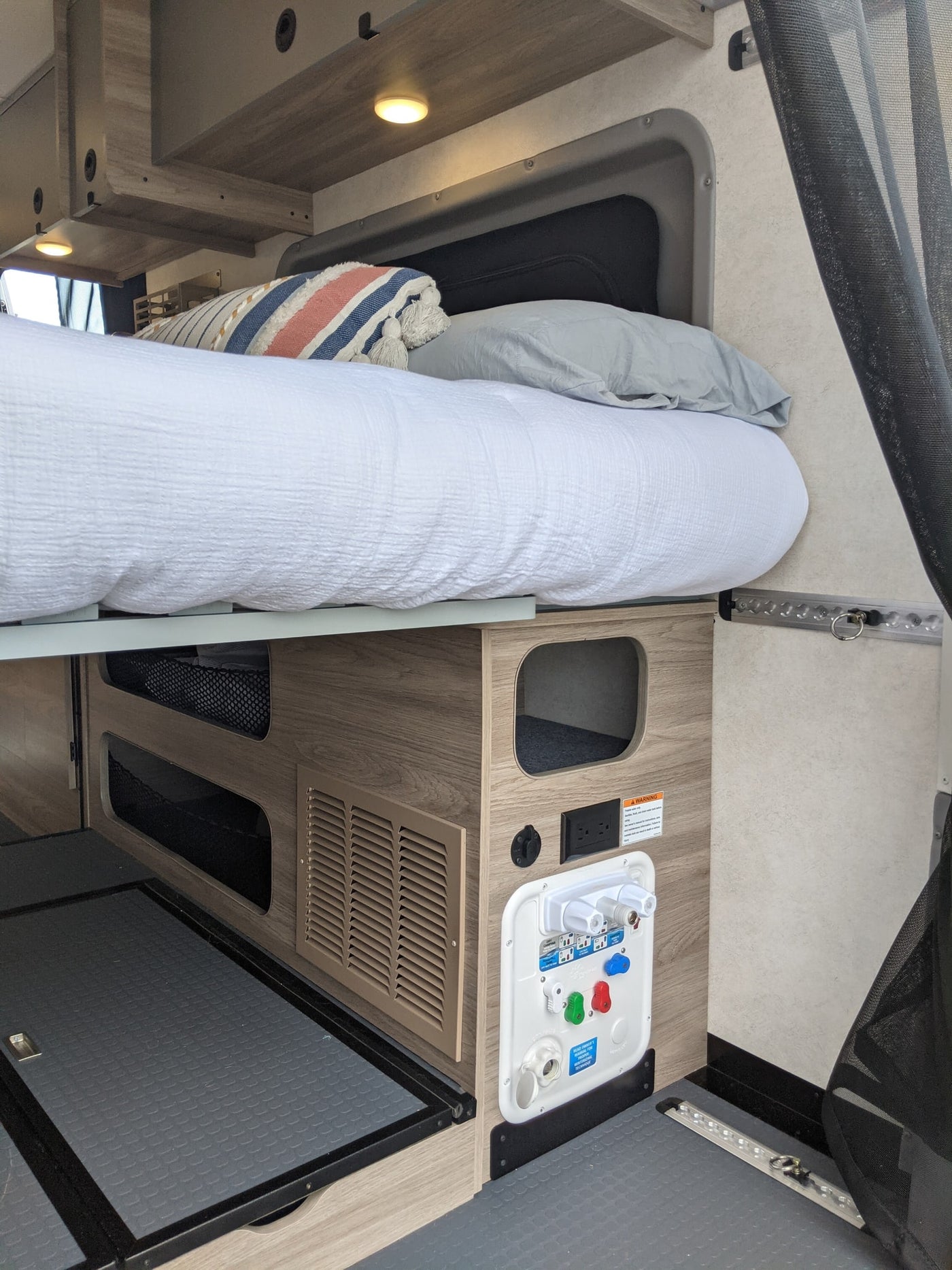  dashboard. Ocean with sailboats outside. Fire extinguisher.|Cozy RV rental interior showing a compact kitchen with sink and stovetop — photo 14