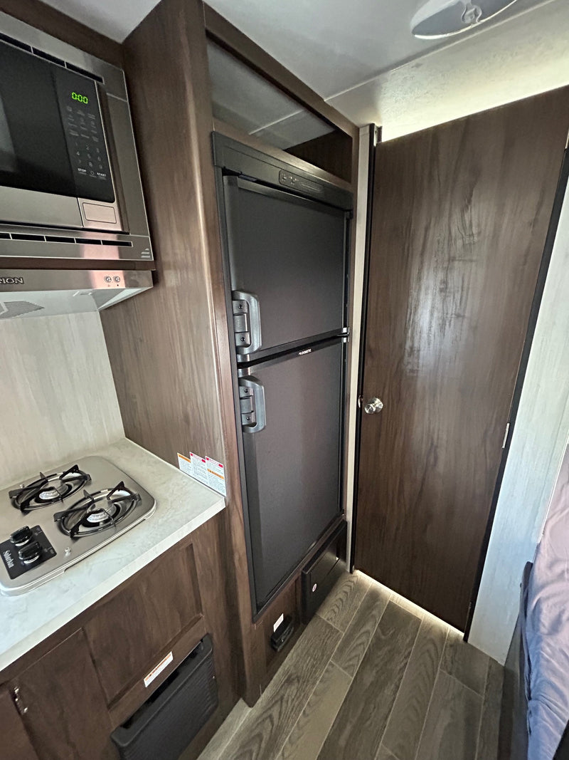  with steps extended and awning rolled up.|This RV rental features a compact bathroom with a shower/tub — photo 2