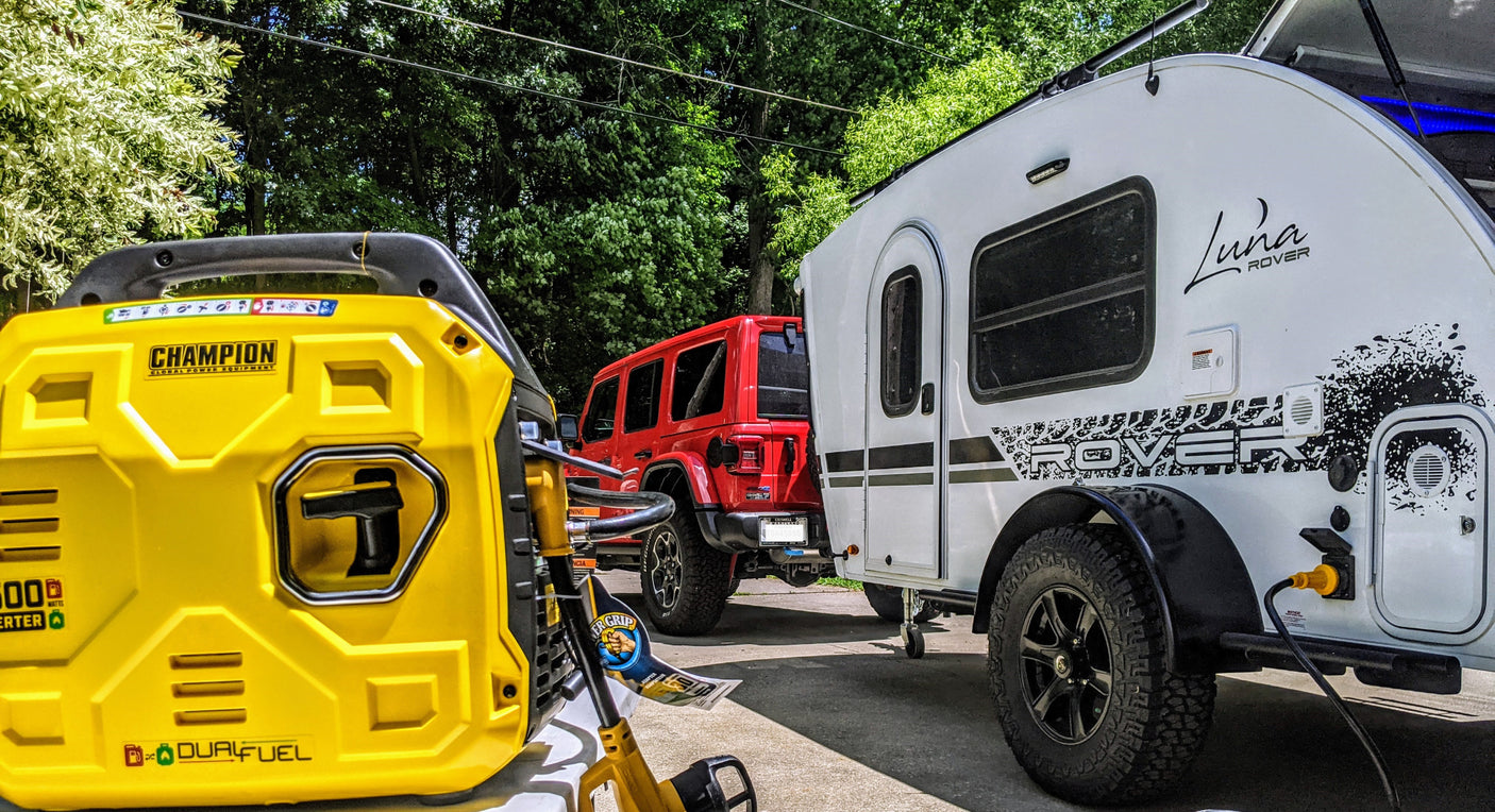 A Champion dual-fuel generator powers a Luna Rover teardrop RV, towed by a red Jeep. Essential gear for outdoor or rv rental trips.