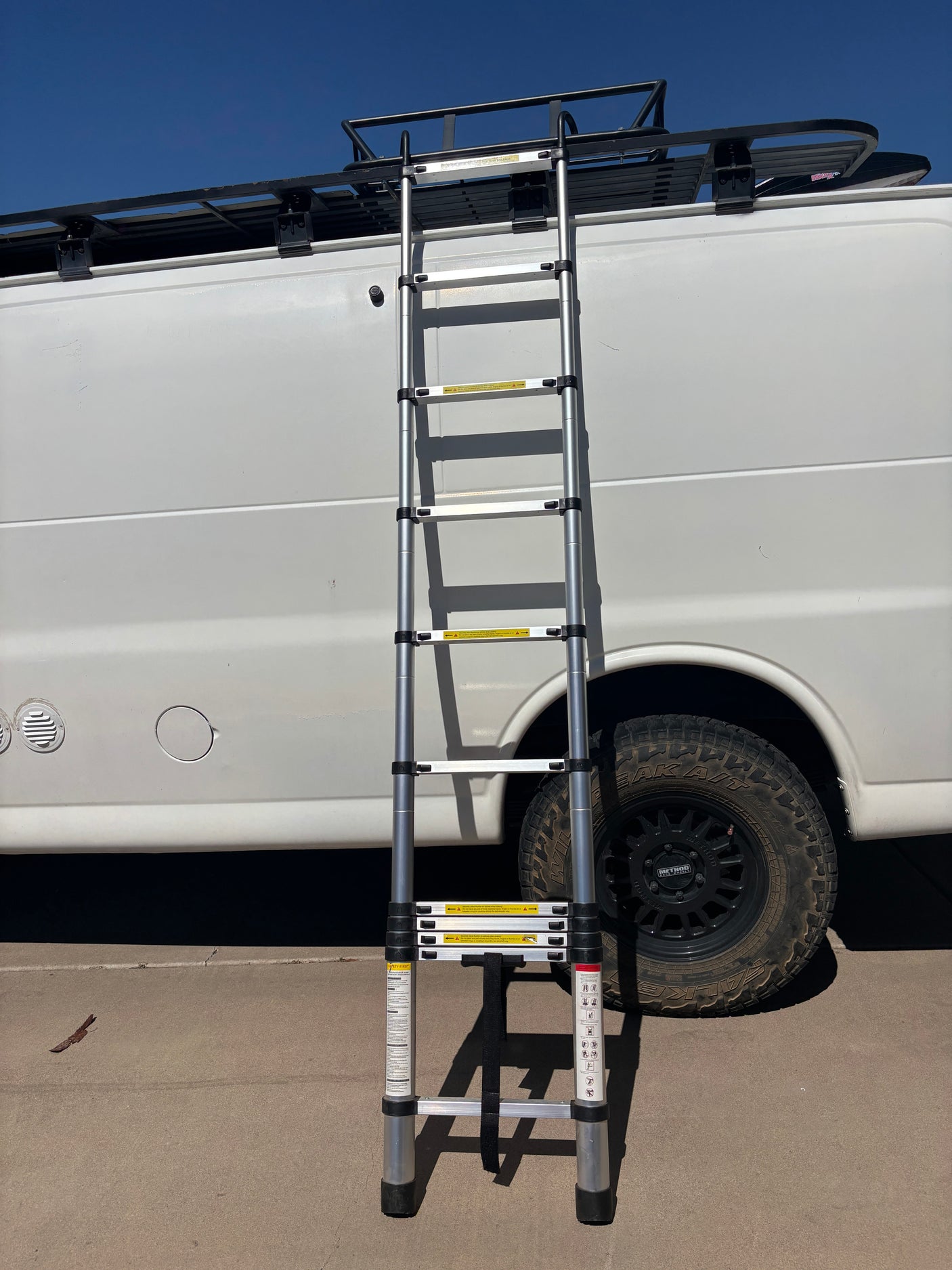 RV rental with an extended telescopic ladder providing access to its roof rack.