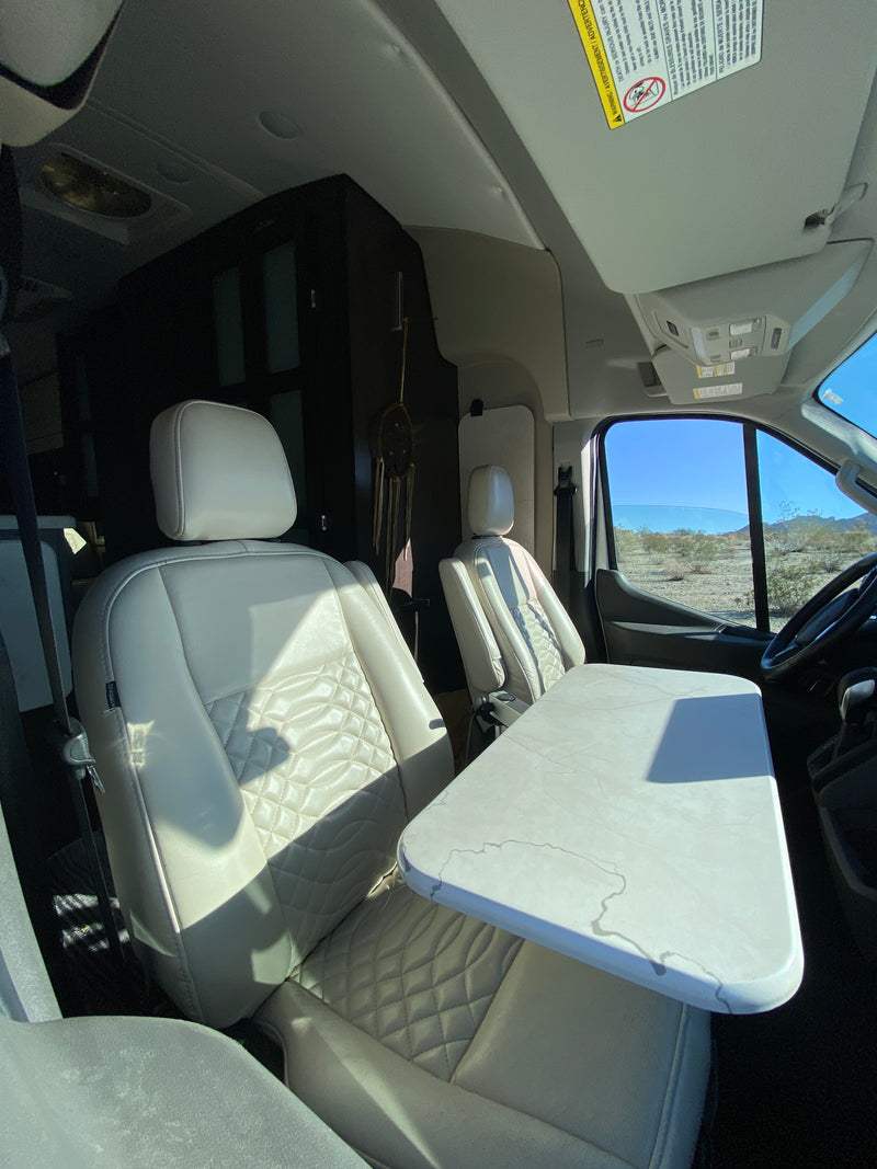 RV rental interior: cream quilted swivel seats, a table, and sunny desert views from the front windshield of this camper van. — photo 6