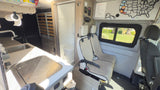 View inside an RV rental: kitchenette with sink/stove, compact bath, and passenger seating, ready for road trips.