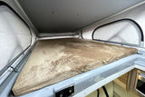 Inside an RV rental: a plush pop-top bed with mesh windows. Perfect camper sleeping area for comfortable travel adventures.