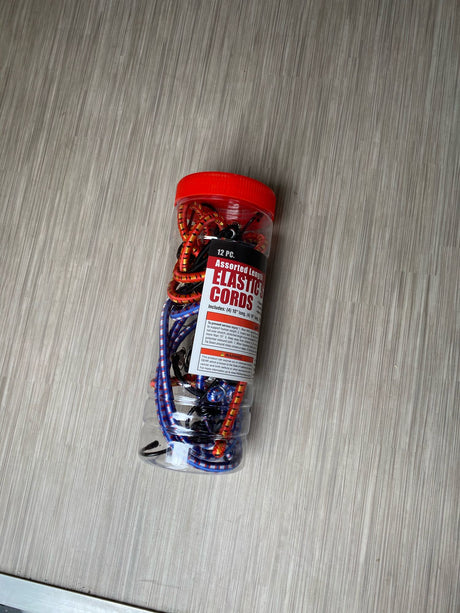A clear container of assorted elastic cords (bungee cords), essential for securing items during your RV rental adventure.