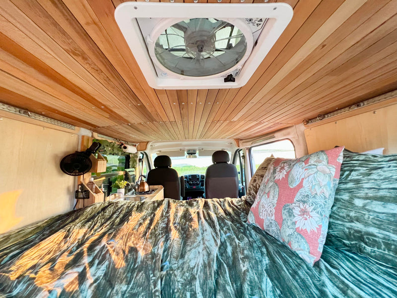 Step into this custom rv rental featuring a beautiful wood-paneled ceiling, comfy bed, and compact kitchenette. — photo 7