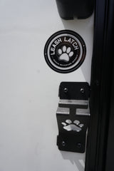 RV rental: Close-up of a "Leash Latch" paw print bracket & sticker, also a bonus beverage opener. Perfect for pet adventures.