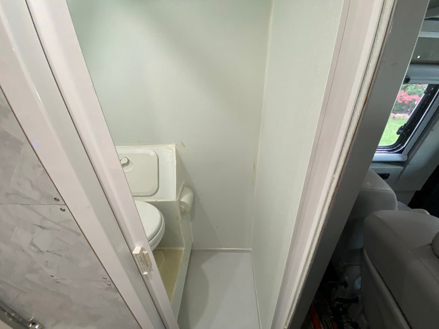  and sleek white & wood design.|This RV rental kitchen features a sleek black pull-down faucet