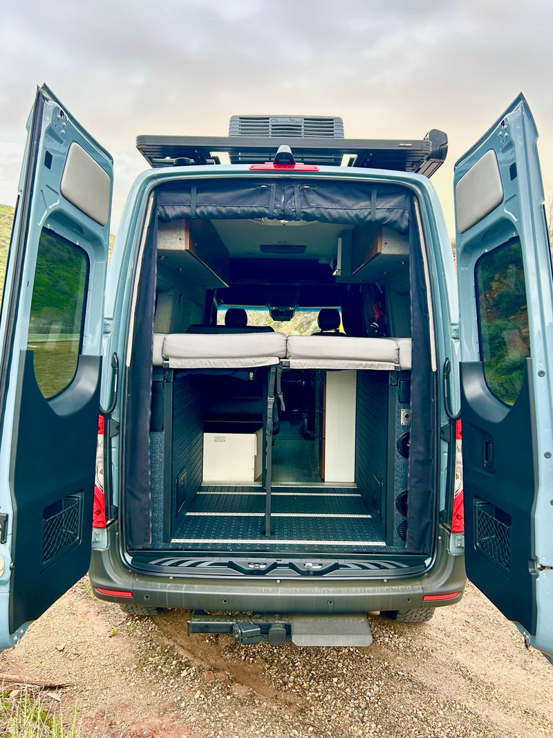 Rear doors open, showcasing the spacious interior of this custom camper van. Ideal for an RV rental getaway & van life. — photo 12