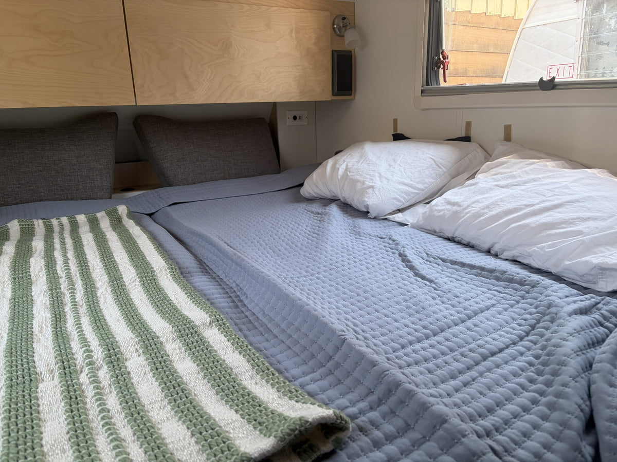  and green forest view through the window.|Cozy RV rental interior featuring a dinette table set for two — photo 7