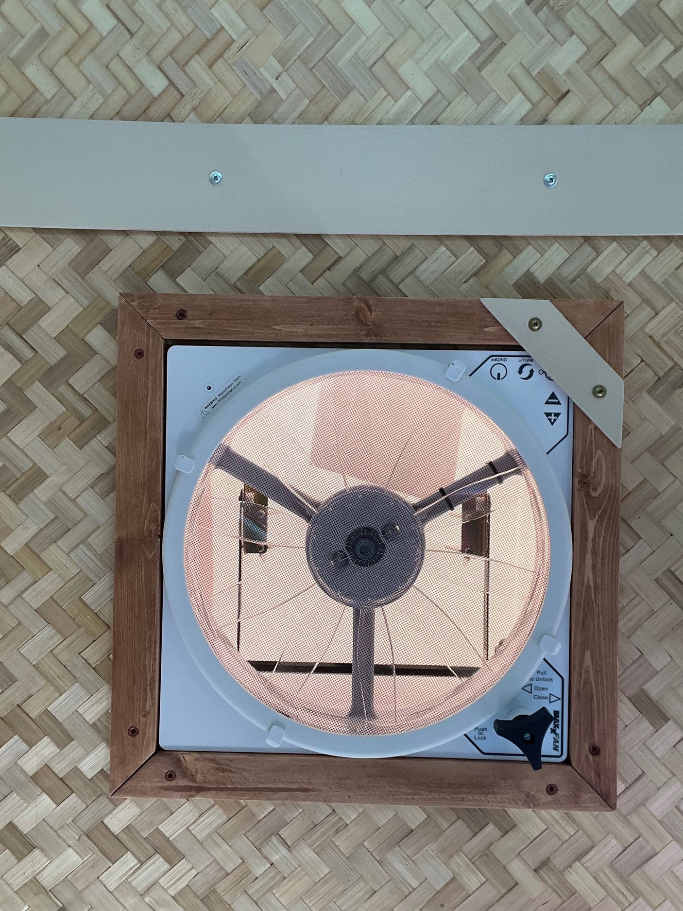 RV rental interior: A Maxx Fan on a woven ceiling with wood trim, enhancing ventilation for comfort.