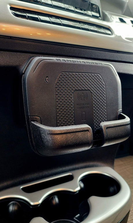 Close-up of a black RAMCHARGER wireless phone charger/holder mounted below dash controls in an RV rental.