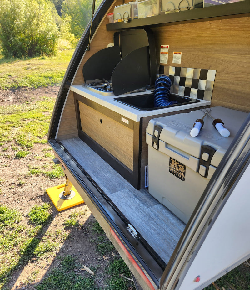 Compact RV rental shows open hatch, revealing a full outdoor kitchen with stove, sink, & K2 cooler. Great for camping! — photo 20