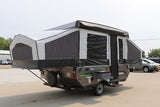 This pop-up camper is set up for your next RV rental adventure, featuring extended tent ends and an awning.