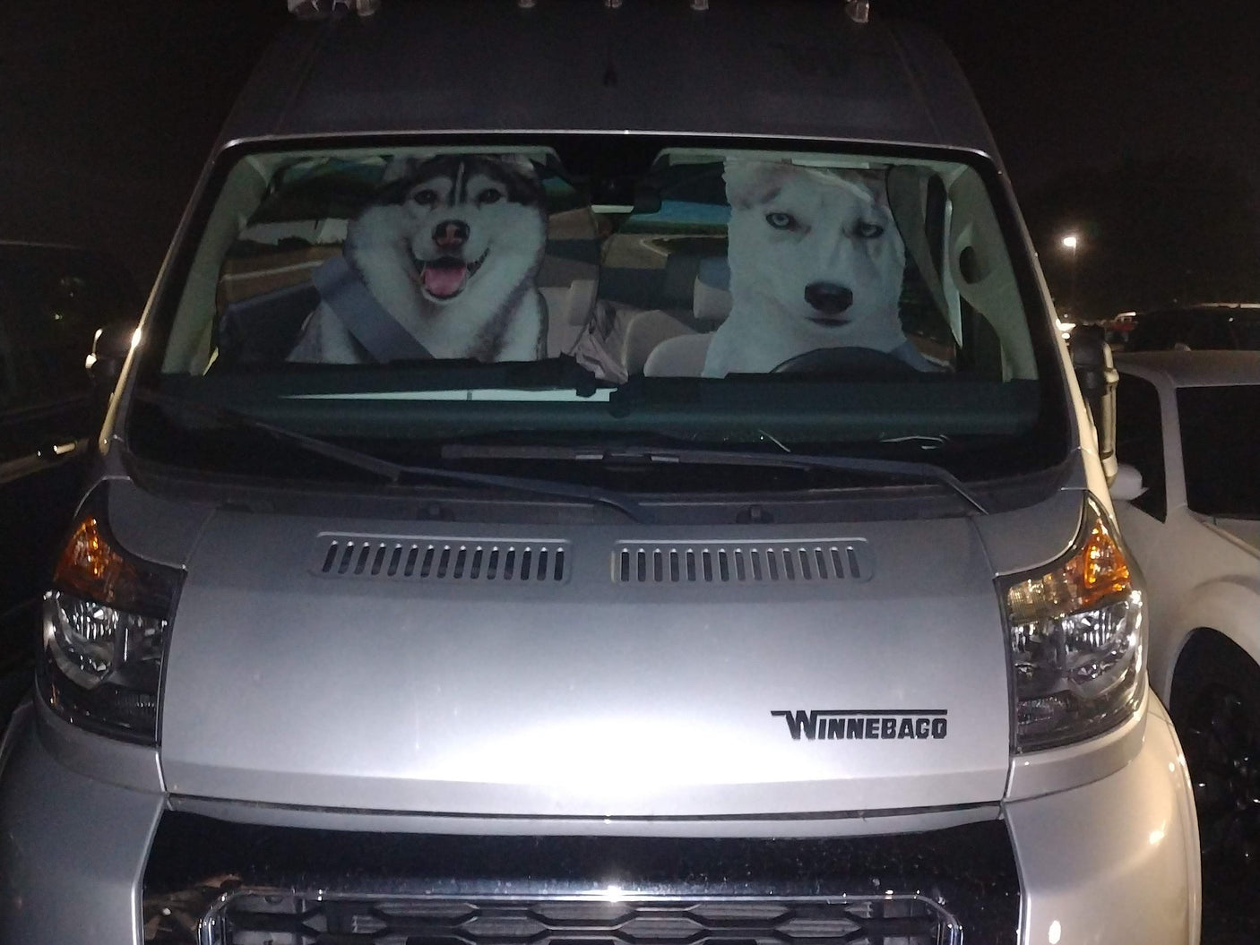 Hilarious dog sunshade featuring two huskies 'driving' a silver Winnebago rv rental van.
